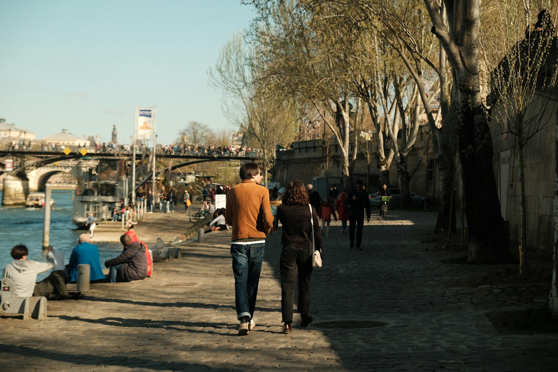 Couple walking hand in hand along the banks of the Seine in Paris