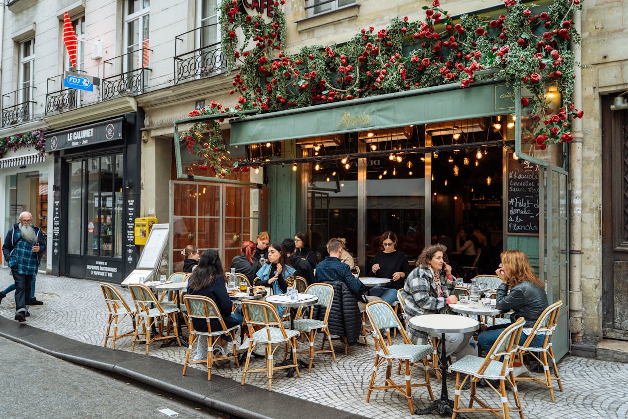 A lively Parisian cafe with outdoor seating on a sunny street in Paris France