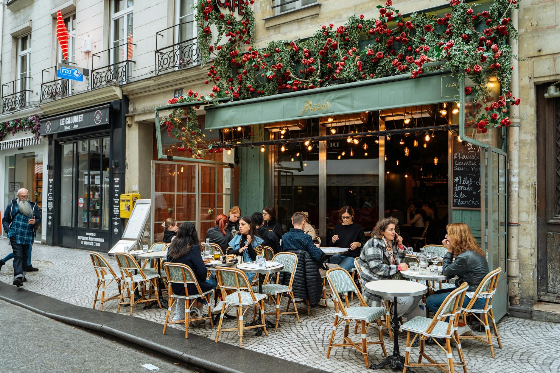 Charming Parisian cafe terrace with outdoor dining on a tree-lined boulevard