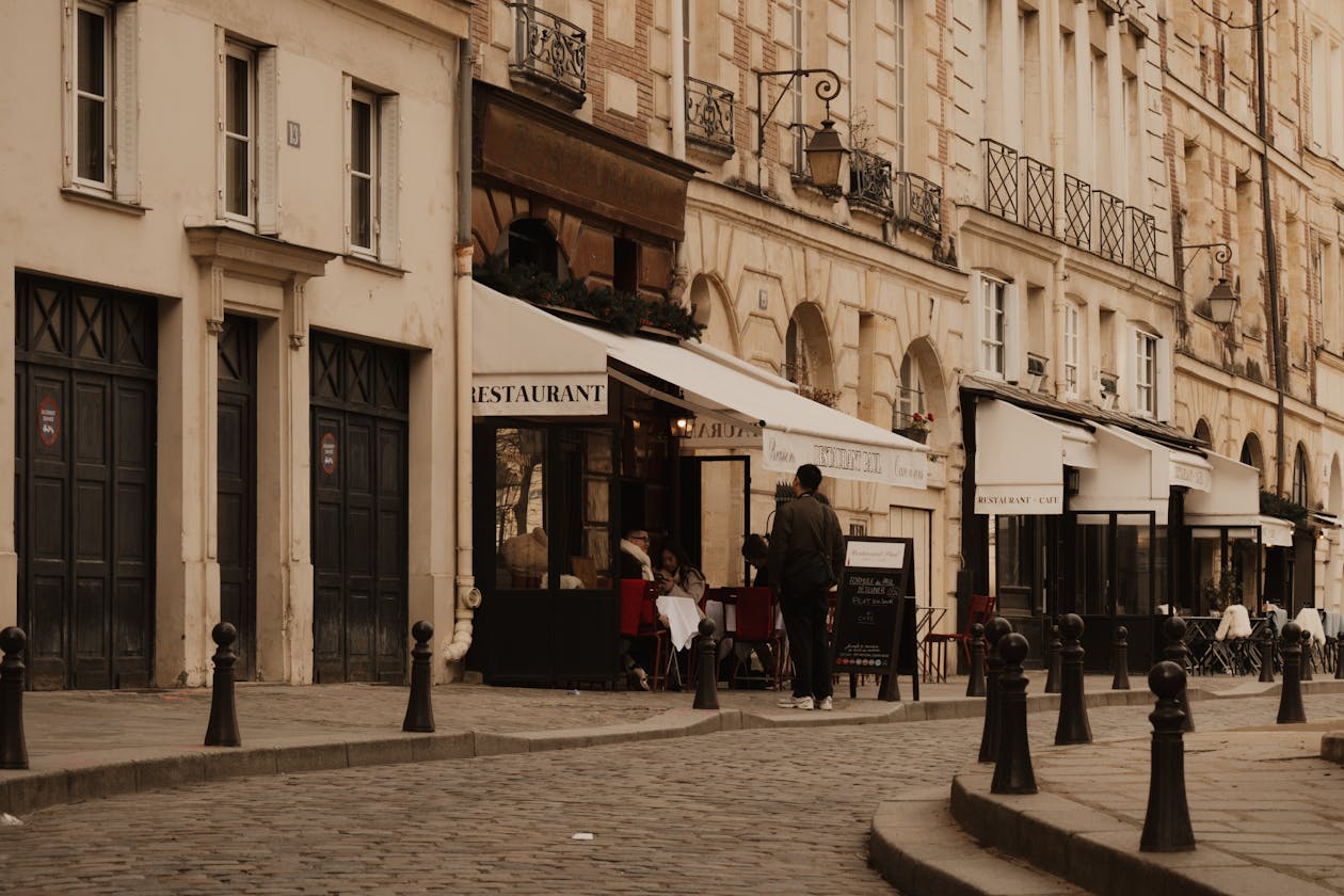 Cobblestone street in Paris with charming cafes and classic Haussmann architecture