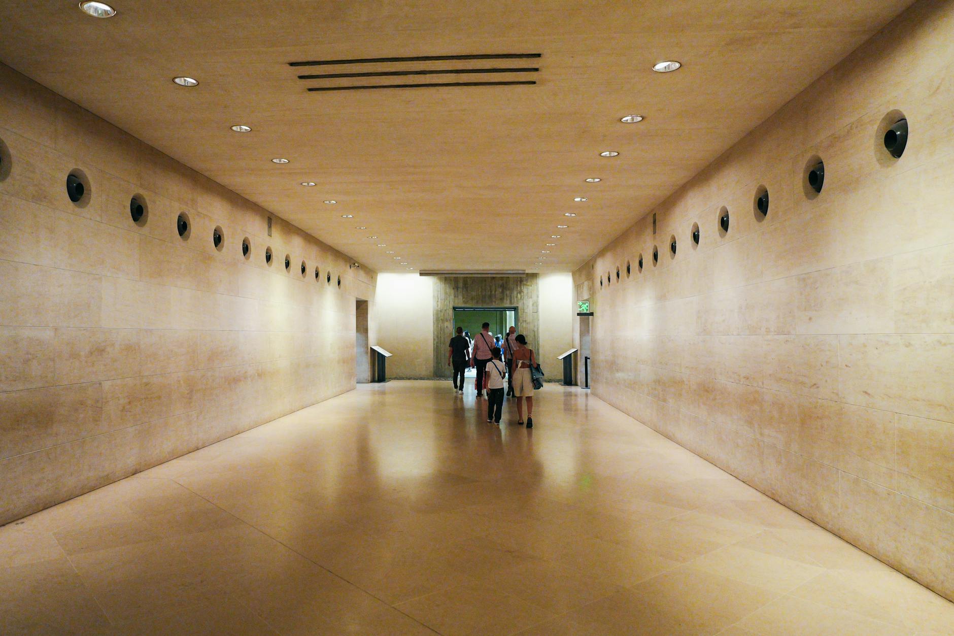 Interior of the Louvre Museum in Paris with visitors admiring the grand gallery