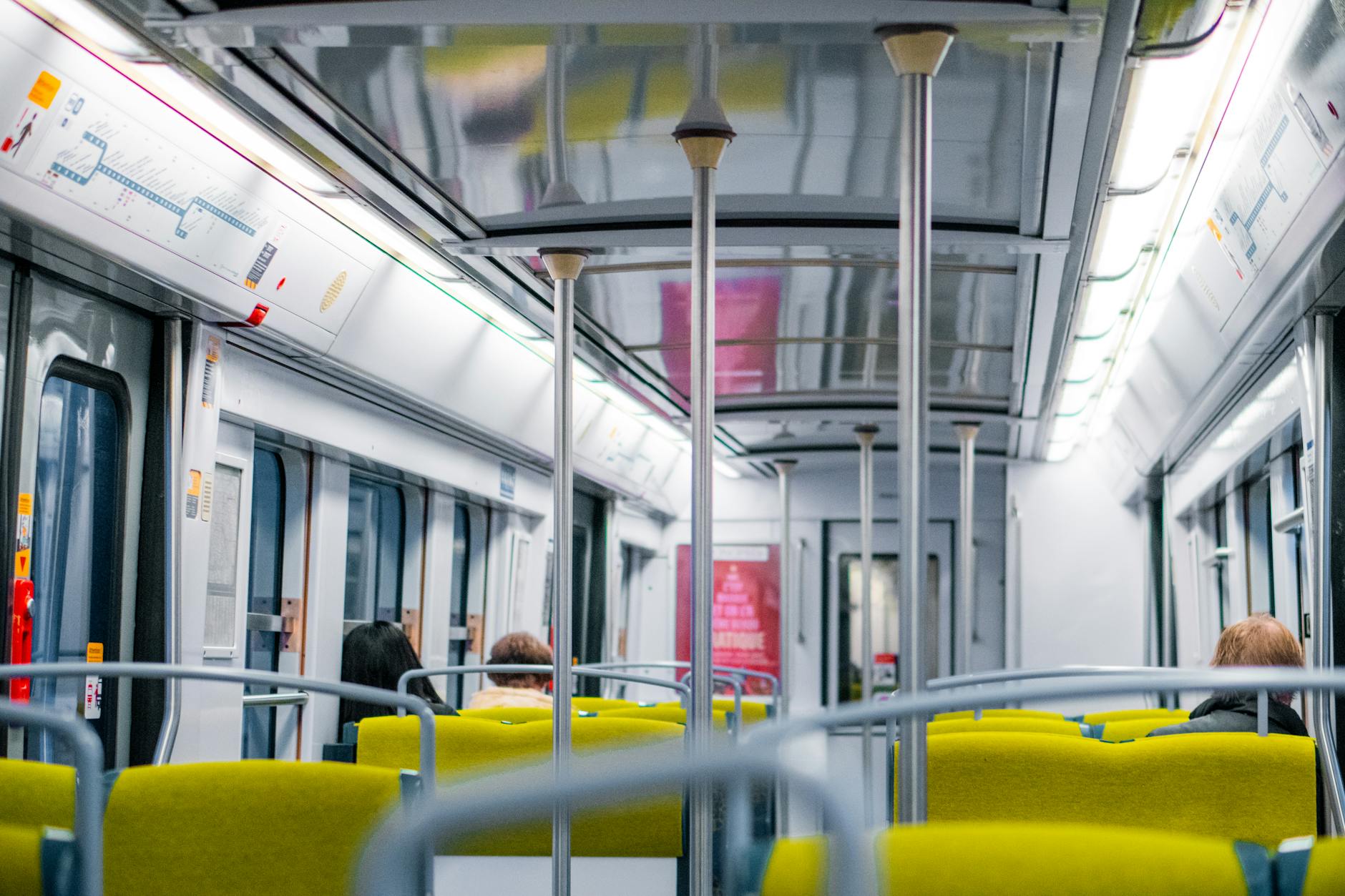 Inside a Paris Metro train car with passengers traveling through the city