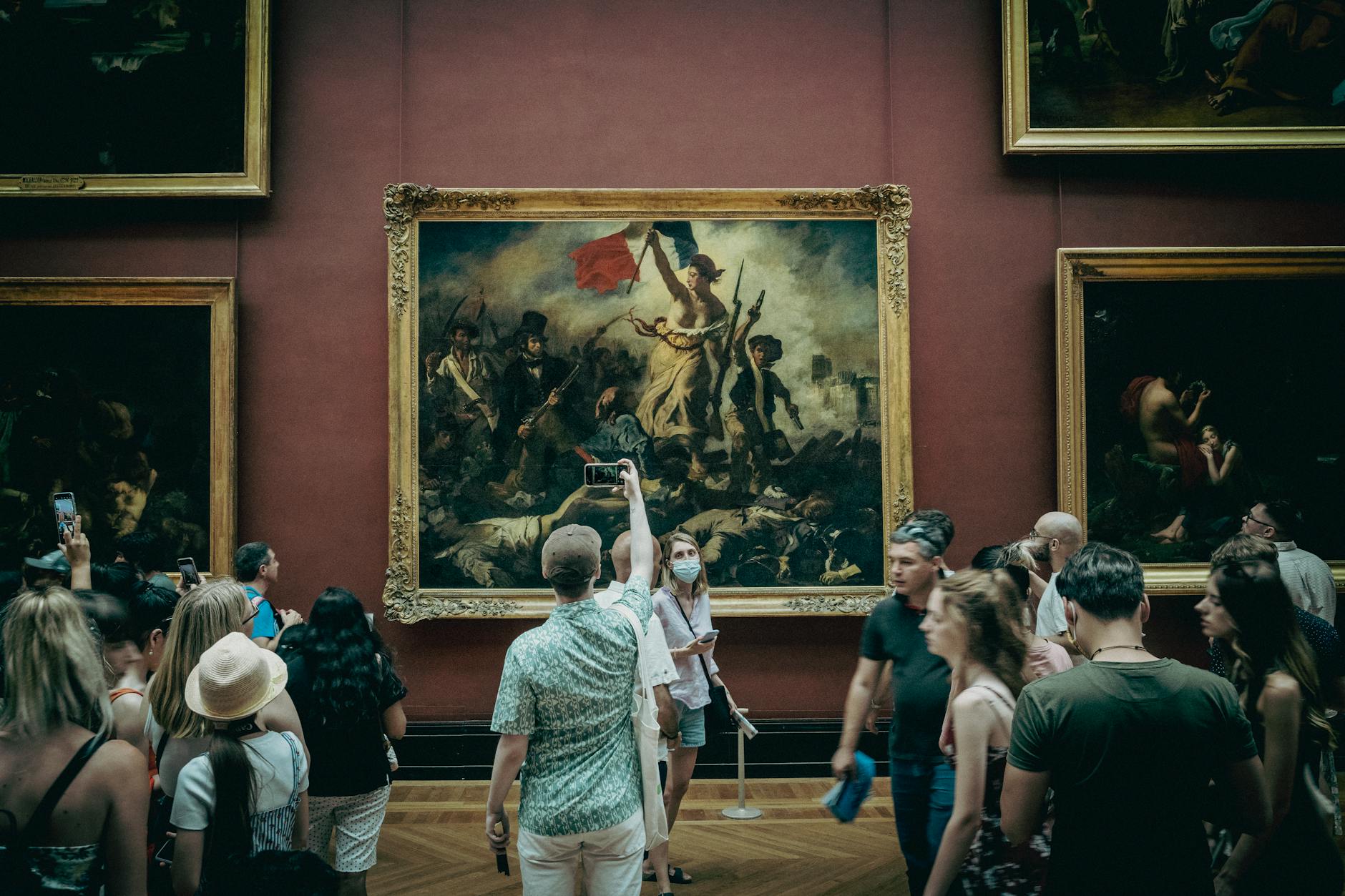 Visitor contemplating a masterpiece painting in a Paris museum gallery