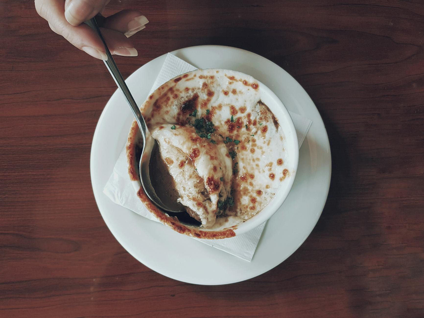 Traditional French onion soup with melted gruyere cheese served in Paris