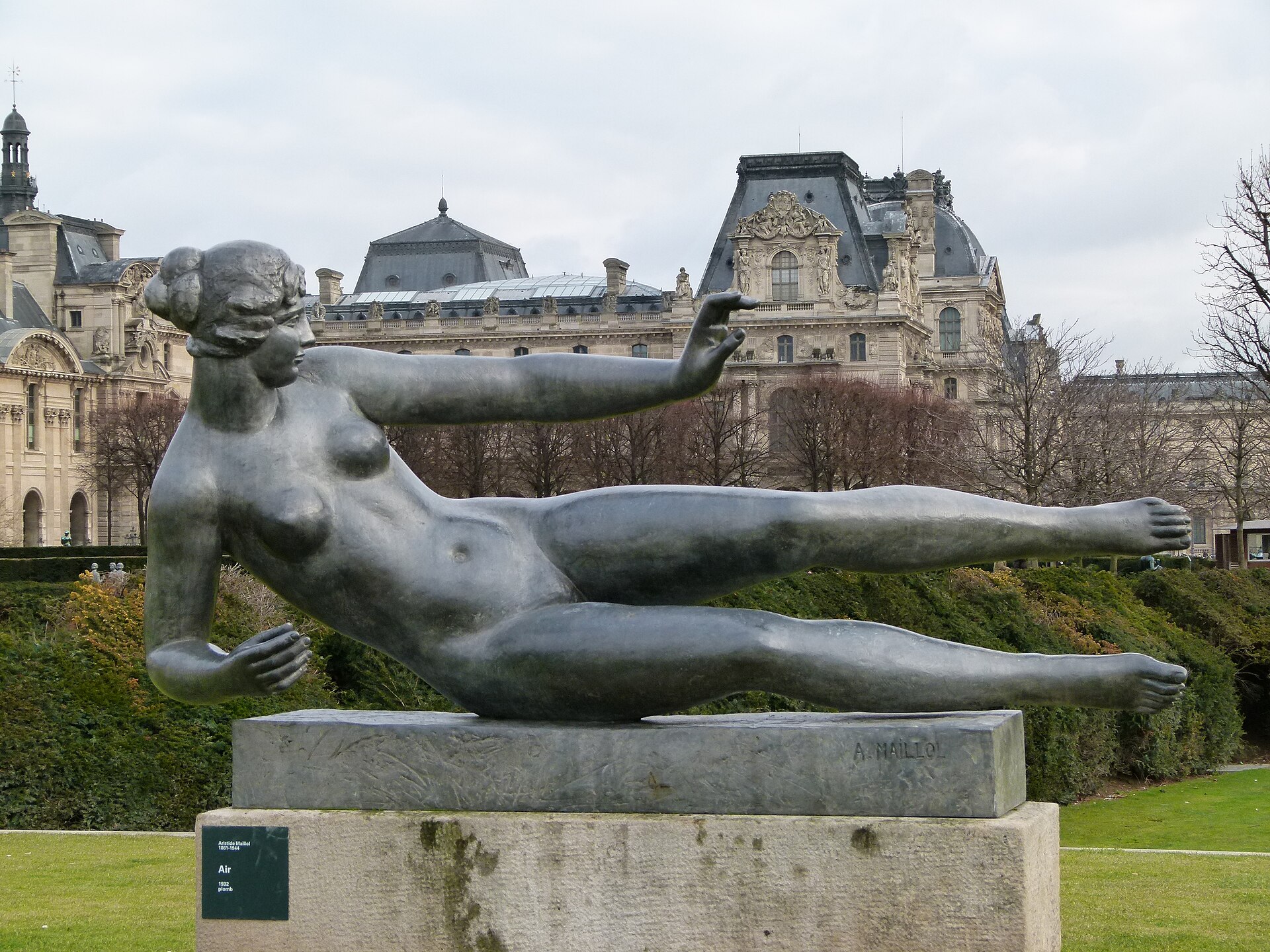 Aristide Maillol's bronze sculpture L'Air, a reclining female figure balanced on a stone plinth, with the Louvre's pavilions behind it